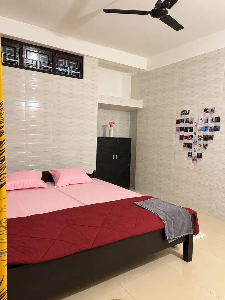 King bed and wardrobe in the 1BHK bedroom, with a heart-shaped photo wall